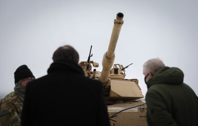 U.S. Ambassador to Lithuania Robert Gilchrist, left, and Lithuanian Minister of Defense Arvydas Anusaukas, right, ask questions to an M1 Abrams tank crew member Jan. 4, 2021, after a color uncasing ceremony. The ceremony officially signifies the...