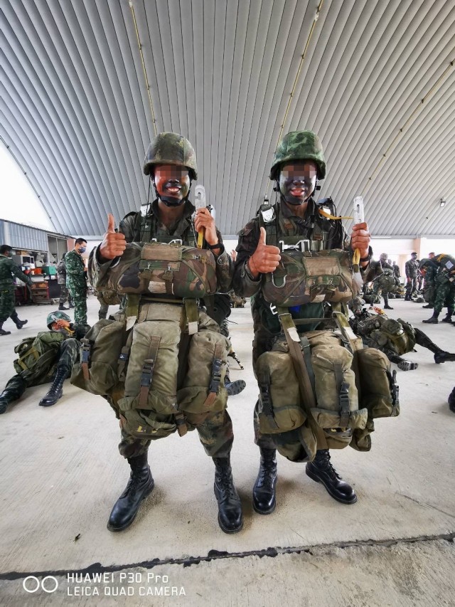 A Green Beret assigned to 1st Special Forces Group (Airborne), left, stands next to a soldier with the Royal Thai Army before a static line combat equipment jump Dec. 26, 2020, in the Kingdom of Thailand. From Oct. 17 to Dec. 29, 2020, he attended the RTA’s Ranger School and earned their Ranger Badge, becoming the first U.S. service member to attend and graduate the course in more than 40 years. (This photo has been altered to protect the identities of those on camera for security purposes.)