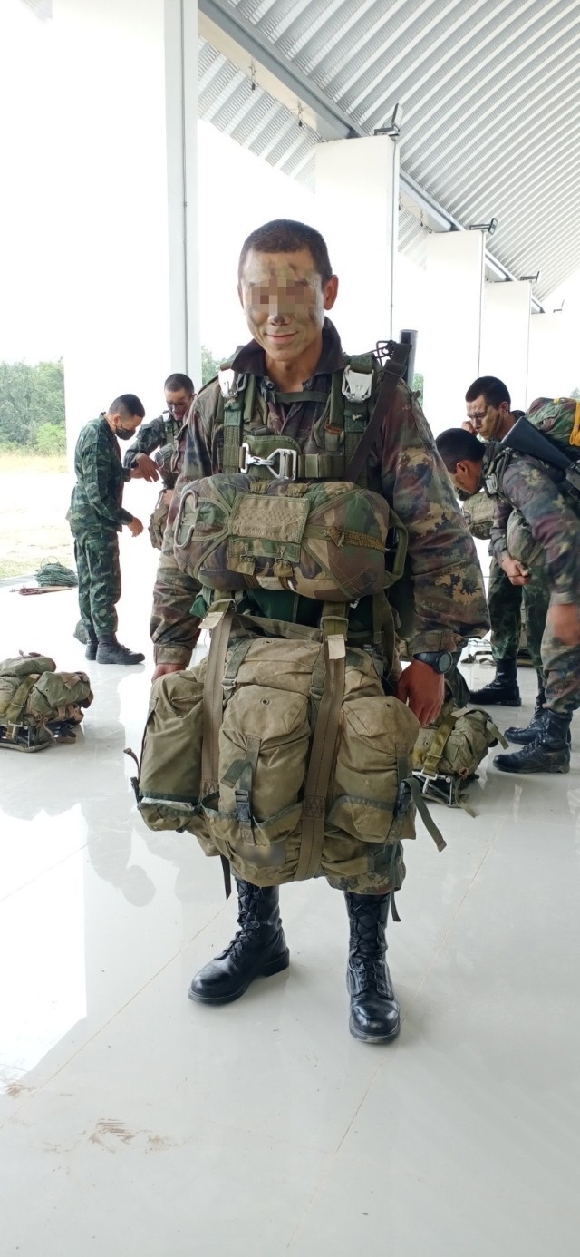A Green Beret assigned to 1st Special Forces Group (Airborne) stands with a combat load prior to a static line combat equipment jump Dec. 26, 2020, in the Kingdom of Thailand. From Oct. 17 to Dec. 29, 2020, he attended the Royal Thai Army’s Ranger School and earned their Ranger Badge, becoming the first U.S. service member to attend and graduate the course in more than 40 years. (This photo has been altered to protect the identity of the person for security purposes.)