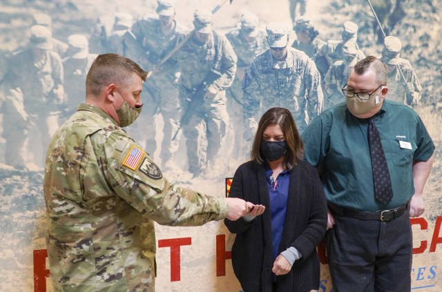 Garrison Commander, Col. Jarrod Moreland (left), presents commander&#39;s coins and certificates to two Army & Air Force Exchange Service employees Jan. 6, 2021 for their heroism and quick thinking which saved the lives of two individuals in separate incidents at Fort Huachuca, Arizona. Gidget Rivera, an AAFES service station employee, and Daniel Fox, a supervisor at Popeye’s Fried Chicken, were recognized for their customer care and heroism.
