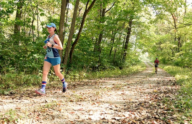 Suzie Stephensen, followed by Mark Kramer, jogs along a trail in the 1908 Ultra Challenge trail run Sept. 26, 2020, near Camp Miles. Stephensen placed first in the women's division by completing 64.4 miles in the 19-hour race. Photo by Prudence Siebert/Fort Leavenworth Lamp