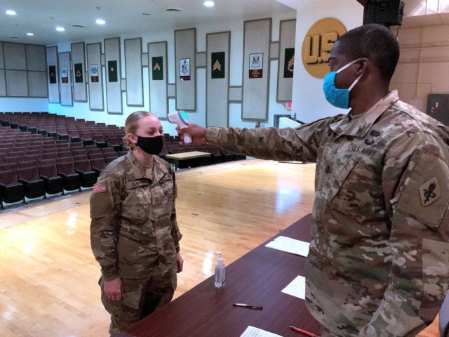 Staff Sgt. Michael White, and instructor with the 187th Medical Battalion, takes Pfc. Amaya Cerutti’s temperature after she returned from Holiday Block Leave.