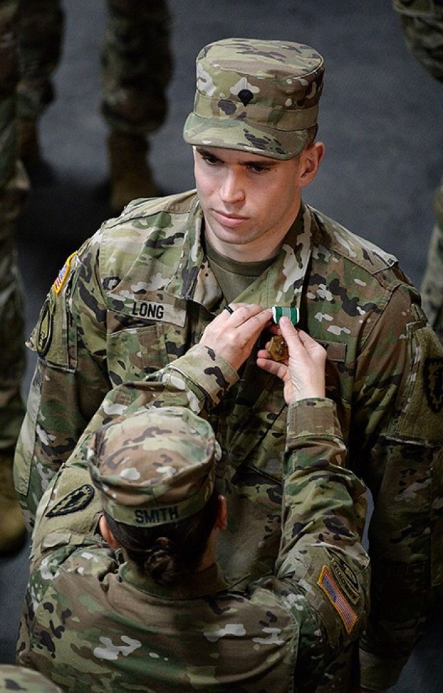 Col. Caroline Smith, 15th Military Police Brigade commander, pins Spc. Shelby Long with the Army Commendation Medal during an awards ceremony for members of X Platoon, who had recently returned from an eight-month Operation Inherent Resolve mission, March 17, 2020, at the Headquarters and Headquarters Company, 705th MP Battalion (Detention) company operations facility. Photo by Prudence Siebert/Fort Leavenworth Lamp