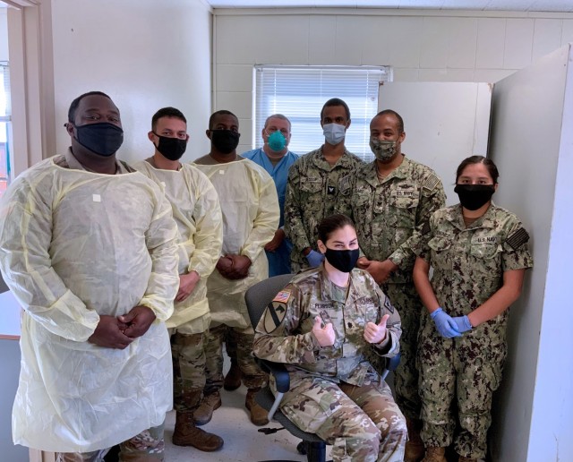 Lt. Col. Nadia M Pearson, MEDCoE Command Surgeon (seated) poses for a group photo with members of the Holiday Block Leave Team Reintegration Testing Cell.