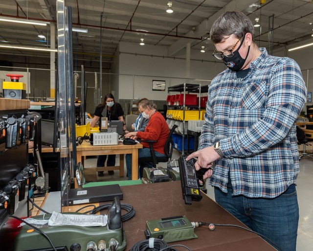 Electronics Mechanic Helper William Scally tests the crew control module for a Tactical Vehicle System.