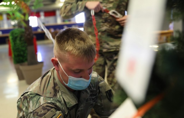 MIHAIL KOGALNICEANU, Romania – Spc. Joshua Smith, Area Support Group-Black Sea, Religious Affairs non-commissioned officer in charge, Alabama National Guard, hangs a tag with names of children on a Christmas tree that was set up here as part of...