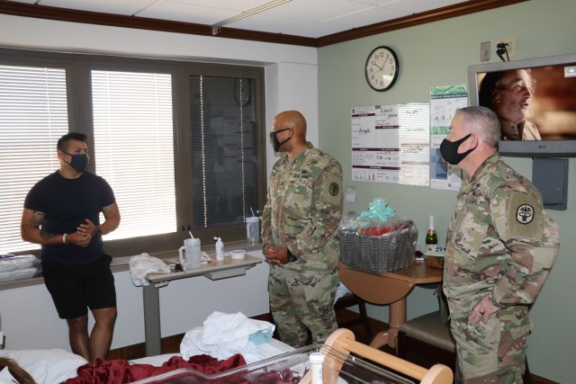 Brig. Gen. Shan Bagby, commander, Brooke Army Medical Center, and Command Sgt. Maj. Thurman Reynolds congratulate new father Isaac Nolasco while visiting him, his wife U.S. Air Force Staff Sgt. Jessica Ojeda-Nolasco, a C5 aviation research manager...