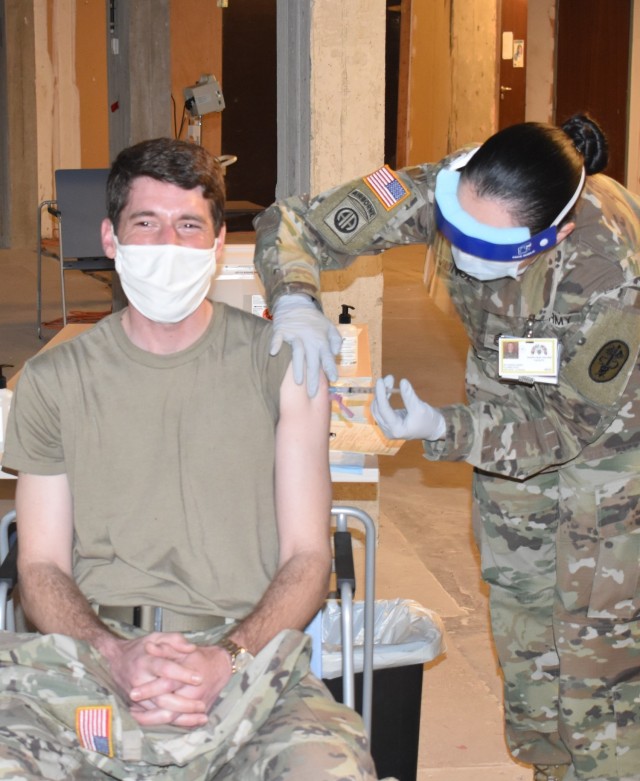 MONS, Belgium – Chief Warrant Officer 2 Chris Fox, left, member of the U.S. Army at SHAPE, receives a COVID-19 vaccination Jan. 8 at the SHAPE Healthcare Facility at Mons, Belgium. The SHAPE Healthcare Facility and Brussels Army Health Clinic...