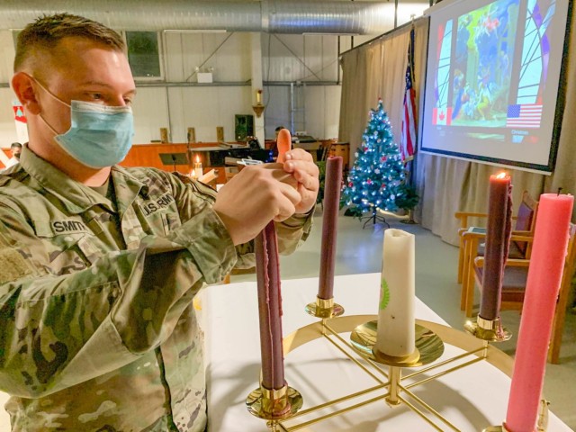 MIHAIL KOGALNICEANU, Romania – Spc. Joshua Smith, Area Support Group-Black Sea, Religious Affairs non-commissioned officer in charge, Alabama National Guard, lights Nativity candles for the Christmas Eve Service that was conducted by both...