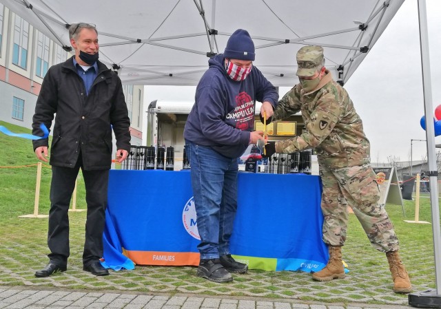 MWR Business Operations Chief Mark Smith (left) and U.S. Army Garrison Command Sgt. Maj. Christopher Truchon (right) look on as Wiesbaden Entertainment Center Manager Bill Montgomery cuts the ribbon to mark the opening of the new Silver...