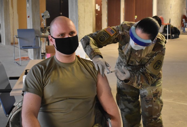 MONS, Belgium – Sgt. Andrew Petersen, left, biomedical equipment technician at SHAPE Healthcare Facility, receives a COVID-19 vaccination at the healthcare facility Jan. 8 at Mons, Belgium. The SHAPE Healthcare Facility and Brussels Army Health...
