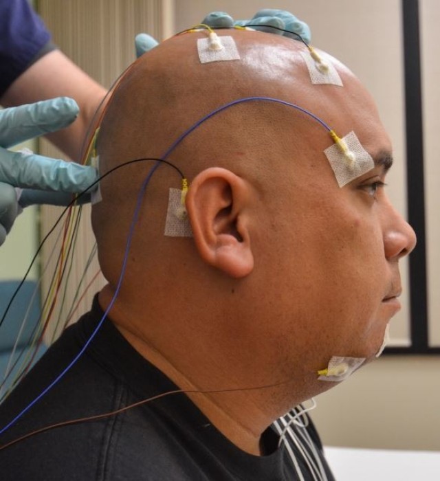 U.S. Army Sgt. 1st Class Bobby M. Scharton, a platoon sergeant with 17th Fires Brigade, 7th Infantry Division, remains still as Christopher Taylor, a sleep technician with Madigan Army Medical Center, applies a sensor during a sleep study at Joint Base Lewis-McChord, Wash., Nov. 22, 2013. Physicians use data from the studies to diagnose severe sleep disorders like sleep apnea and insomnia. 