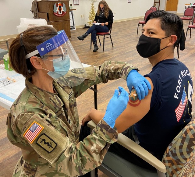 Lyster Army Health Clinic Commander Lt. Col. Danielle Rodondi administers the COVID-19 vaccine to Staff Sgt. Ryan Asca, EMS paramedic. 
