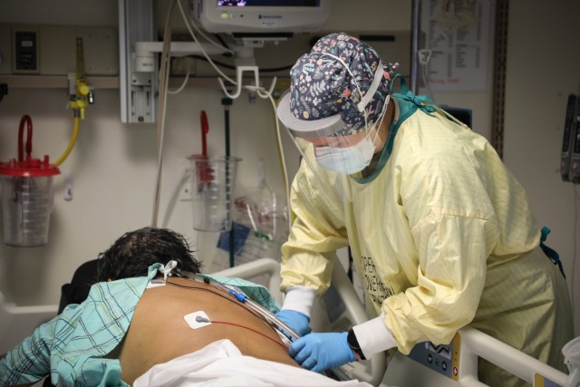 U.S. Navy Lt. Codi Kelly, a critical care nurse with the Rural Rapid Response Team, cares for a patient while working in the COVID-19 ward at the Northern Navajo Medical Center, Shiprock, N.M., Dec. 31, 2020.  U.S. Northern Command, through U.S....