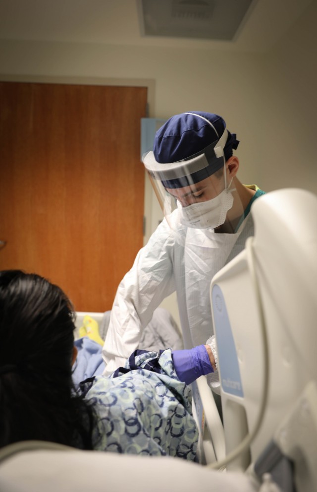 U.S. Navy Lt. j.g Dylan Maxwell, a critical care nurse with the Rural Rapid Response Team, adjusts a blood pressure cuff on a patient while working in the COVID-19 ward at the Northern Navajo Medical Center, Shiprock, N.M., Dec. 23, 2020.  U.S....