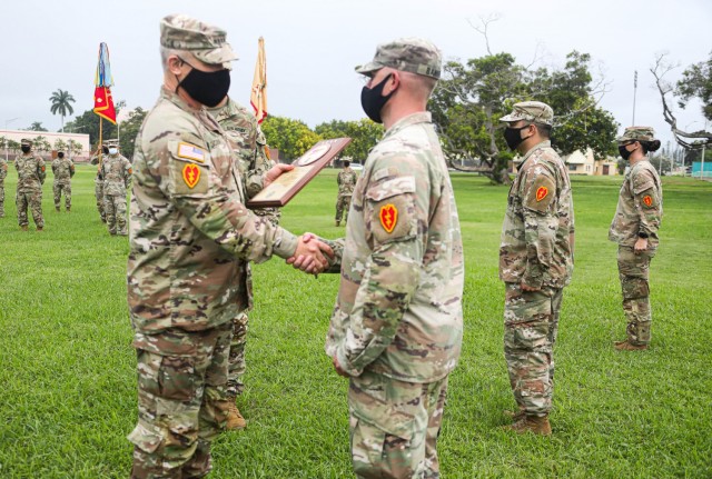 Gen. Paul LaCamera, Commanding General of the United States Army Pacific, passes a plaque to a Soldier from Echo Company, 3rd General Support Aviation Battalion, 25th Aviation Regiment, 25th Combat Aviation Brigade, 25th Infantry Division, on Schofield Barracks, Hawaii, Nov. 20, 2020. Echo Company received the plaque for winning the 2019 Army Achievement Award for Maintenance Excellence.