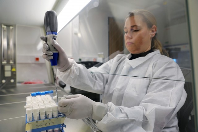 Nina Gruhn, a senior microbiologist in the Biological Analysis Division at Public Health Command Europe, demonstrates the COVID-19 surveillance testing process.