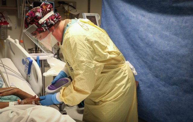 U.S. Navy Lt. Kathryn Hrezo, a critical care nurse with the Rural Rapid Response Team, checks a patient’s blood sugar level, while working in the COVID-19 ward at the Northern Navajo Medical Center, Shiprock, N.M., Dec. 31, 2020. U.S. Northern...
