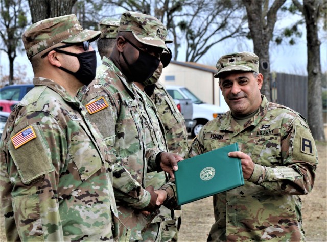 U.S. Army Lt. Col. Benjamin Kenion, commander 3-312th Training Support Battalion, Fort Meade, Maryland, congratulates Soldiers part of the battalion command staff during an awards ceremony for recognition of their hard work and dedication during the mobilization process and achieving mission readiness December 18 at Fort Hood, Texas. The unit is on a yearlong assignment to Fort Hood in support of operations for First Army Division West, 120th Infantry Brigade. (U.S. Army Reserve Photo Staff Sgt. Erick Yates)
