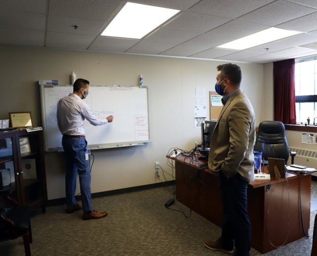 Jim Veto (left) and Corey Hotle (right) discuss some of the data being tracked, analyzed, and reported by HQ, JMC employees and JMC subordinate installations to enhance JMC's ability to assess risk for supply chain availability and surge. ...