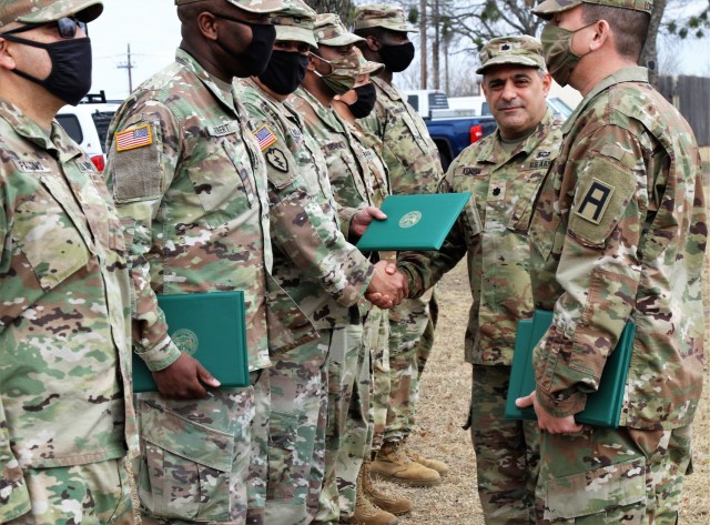 U.S. Army Lt. Col. Benjamin Kenion, commander 3-312th Training Support Battalion, Fort Meade, Maryland, and Command Sgt. Maj. Michael Lopez, senior enlisted advisor for the Battalion, congratulates Soldiers part of the battalion command staff during an awards ceremony for recognition of their hard work and dedication during the mobilization process and achieving mission readiness December 18 at Fort Hood, Texas. The unit is on a yearlong assignment to Fort Hood in support of operations for First Army Division West, 120th Infantry Brigade. (U.S. Army Reserve Photo Staff Sgt. Erick Yates)