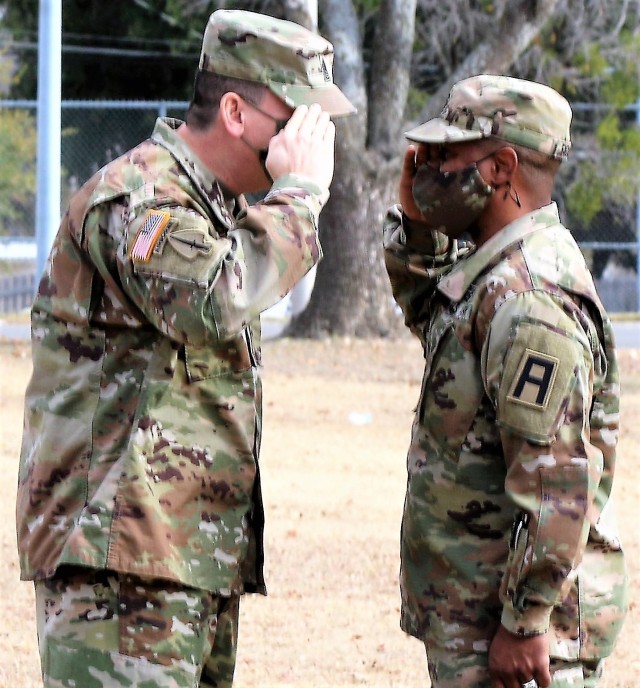 U.S. Army Command Sgt. Maj. Michael Lopez, senior enlisted advisor for 3-312th Training Support Battalion, Fort Meade, Maryland, salutes 1st Sgt. Michael Figueroa, Headquarters & Headquarters Company first sergeant, during a formation to commend Soldiers from the Battalion for achieving mission readiness during the mobilization process December 18 at Fort Hood, Texas. The unit is on a yearlong assignment to Fort Hood in support of operations for First Army Division West, 120th Infantry Brigade. (U.S. Army Reserve Photo Staff Sgt. Erick Yates)