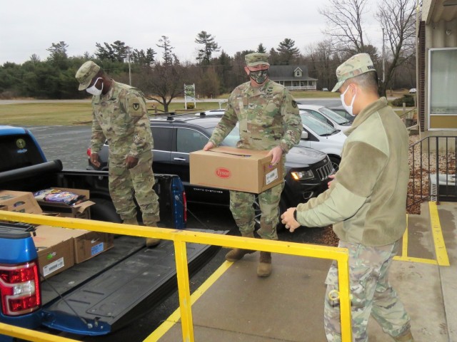 Fort McCoy, Wis., personnel and Soldiers with Headquarters and Headquarters Company (HHC), Fort McCoy Garrison, are shown after they traveled to Neighbor-for-Neighbor Inc. in Tomah, Wis., on Dec. 21, 2020, for the third and final drop-off from the...