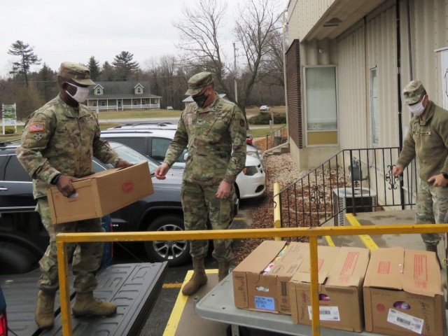 Fort McCoy, Wis., personnel and Soldiers with Headquarters and Headquarters Company (HHC), Fort McCoy Garrison, are shown after they traveled to Neighbor-for-Neighbor Inc. in Tomah, Wis., on Dec. 21, 2020, for the third and final drop-off from the...
