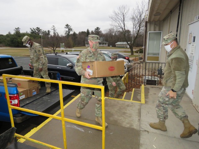Fort McCoy, Wis., personnel and Soldiers with Headquarters and Headquarters Company (HHC), Fort McCoy Garrison, are shown after they traveled to Neighbor-for-Neighbor Inc. in Tomah, Wis., on Dec. 21, 2020, for the third and final drop-off from the...