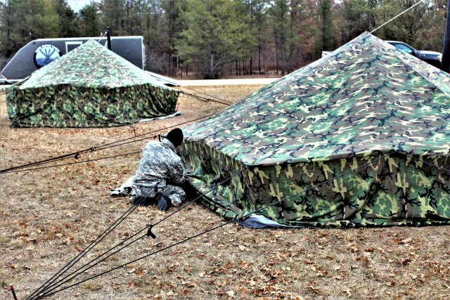 A Fort McCoy Cold-Weather Operations Course (CWOC) Class 21-01 student helps set up an Arctic 10-person tent Dec. 15, 2020, at a South Post training area at Fort McCoy, Wis. CWOC students are trained on a variety of cold-weather subjects, including snowshoe training and skiing as well as how to use ahkio sleds and other gear. Training also focuses on terrain and weather analysis, risk management, cold-weather clothing, developing winter fighting positions in the field, camouflage and concealment, and numerous other areas that are important to know in order to survive and operate in a cold-weather environment. The training is coordinated through the Directorate of Plans, Training, Mobilization and Security at Fort McCoy. (U.S. Army Photo by Scott T. Sturkol, Public Affairs Office, Fort McCoy, Wis.)