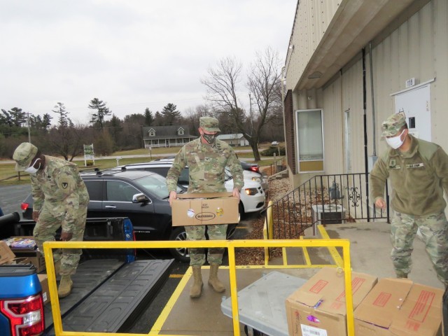 Fort McCoy, Wis., personnel and Soldiers with Headquarters and Headquarters Company (HHC), Fort McCoy Garrison, are shown after they traveled to Neighbor-for-Neighbor Inc. in Tomah, Wis., on Dec. 21, 2020, for the third and final drop-off from the...