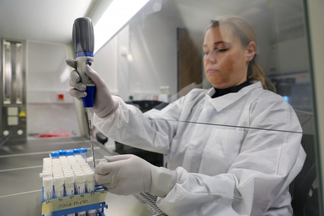 Nina Gruhn, a senior microbiologist in the Biological Analysis Division at Public Health Command Europe, demonstrates the COVID-19 surveillance testing process.