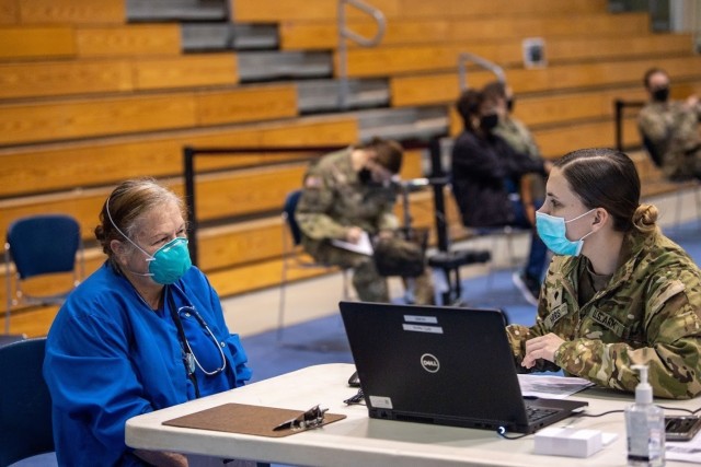 Dr. Christina Keiger, chief of the acute care clinic, checks in at the first station before receiving her COVID vaccination shot at the Solomon Center, Jan. 11.