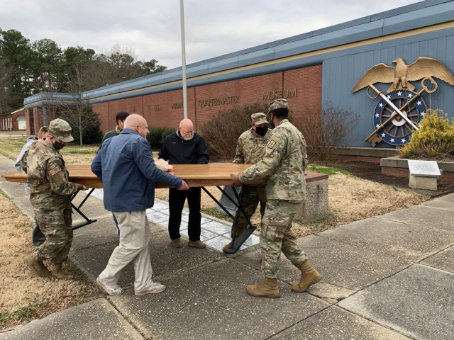 Volunteers carry an M-1903 mess hall table into the Quartermaster Museum Jan. 5. The furniture piece was discovered in a facility workshop by Lee Holland (blue jacket), who donates his time to the museum. After learning of its historical...