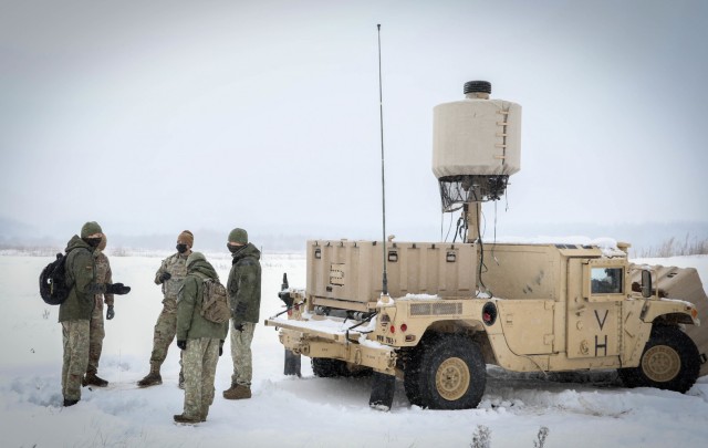 Lithuanian Artillery Battalion Commander Lt. Col. Tomas Nauduzas, left, speaks with U.S. Capt. Spenser Swafford, center, 2nd Battalion, 8th Cavalry Regiment fire support officer, about the capabilities of the U.S. Q-50 Lightweight Counter Mortar...
