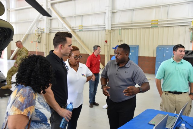 Terrence Skinner, far right, speaks with Masheldia Green, center, item manager for Chinook engines, and Dustin Spane, left, a logistics management specialist for the Chinook helicopters, about training equipment and how his team trains Soldiers in...