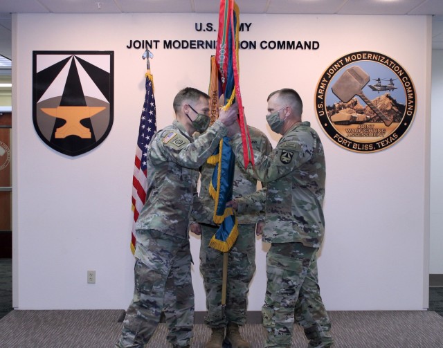 Command Sgt. Maj. Christopher Gunn (right) passes the JMC colors to Col. Tobin Magsig during Gunn’s Relinquishment of Responsibility Ceremony on Jan. 19 at Fort Bliss, Texas. (Photo by Maj. Mike Van Kleeck / U.S. Army Joint Modernization Command)
