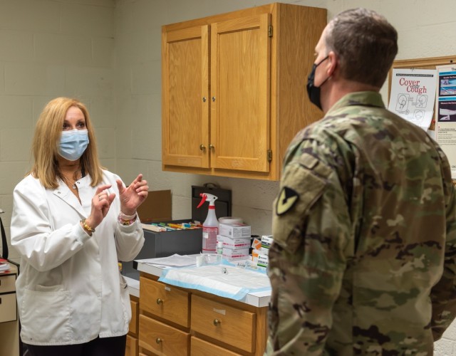 U.S. Army Occupational Health Clinic staff member Debra Generose provides Tobyhanna Commander COL John McDonald with an update on workforce vaccinations.