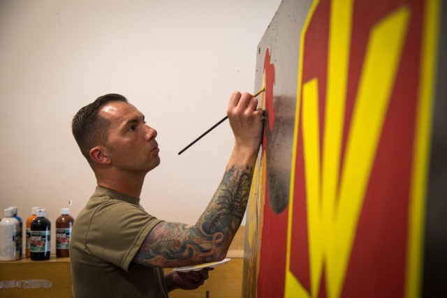 Sgt. 1st Class Brandon Brouillet assigned to Headquarters and Headquarters Battery, 11th Air Defense Artillery Brigade, paints his unit T-Barrier, Oct. 27, 2020, at Al Udeid Air Base. (U.S. Army photo by Staff Sgt. Mariah Jones)