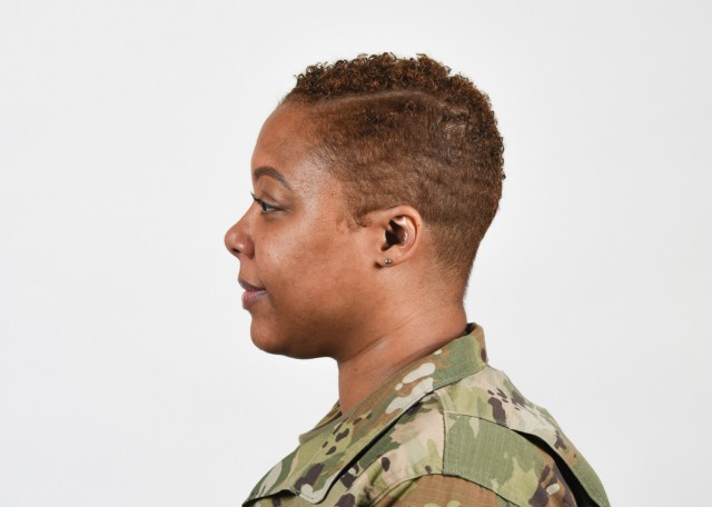 A female Soldier poses for an example photo with hair shorter than 1/4 inch,  natural colored highlights, and earrings in the Army Combat Uniform, in support of an upcoming change in Army grooming and appearance standards.  