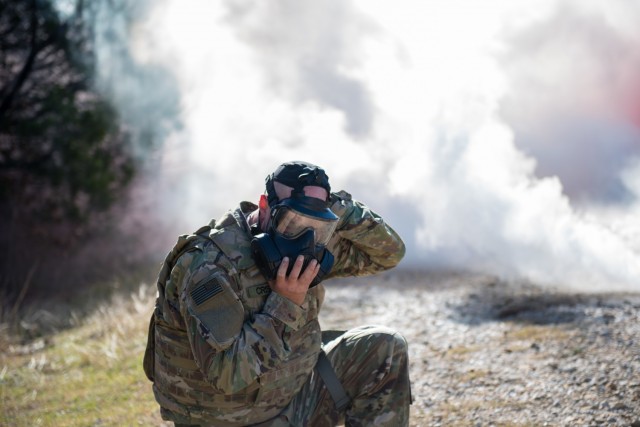 Headquarters and Headquarters Company, 1st Medical Brigade's Sgt. Jeffrey Criswell, dons his protective mask reacting to a chemical, biological, radiological and nuclear threat.  During the Soldier and Noncommissioned Officer of the Year and Best Medic competitions, Soldiers took on challenging tasks testing their basic Soldier and medic skills. (U.S. Army photo by Sgt. 1st Class Kelvin Ringold)