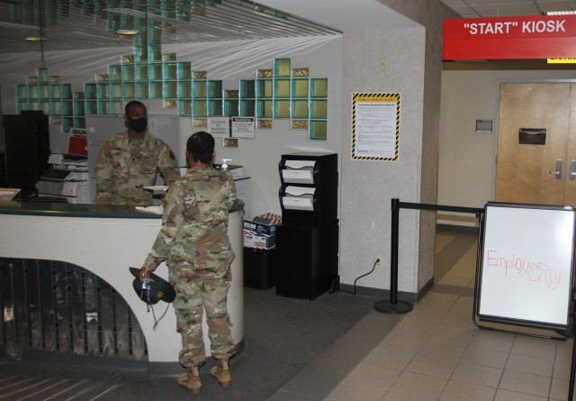 Spc. Handy Paul helps a customer Jan. 15, 2021, at the front desk to the Welcome Center Bldg. 4700 at Fort Sill, Oklahoma. All visitors must enter the building through the east entrance and then stop at the front desk for approval and verification...
