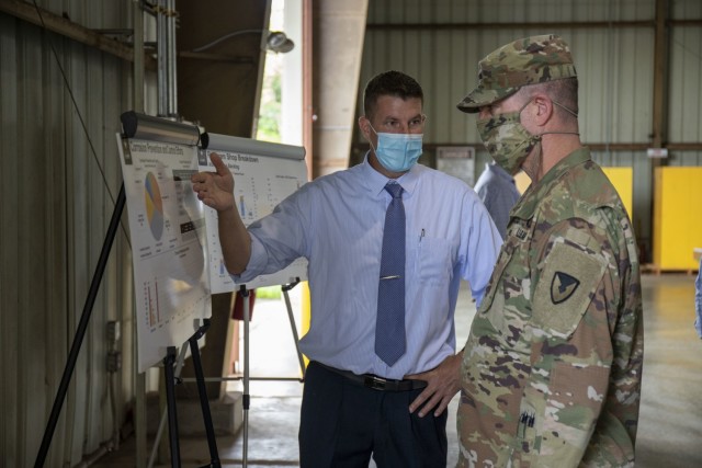 The 402nd Army Field Support Battalion-Hawaii's Sean Mager briefs Army Sustainment Command's commanding general Maj. Gen. Daniel Mitchell on their corrosion prevention and repair program.