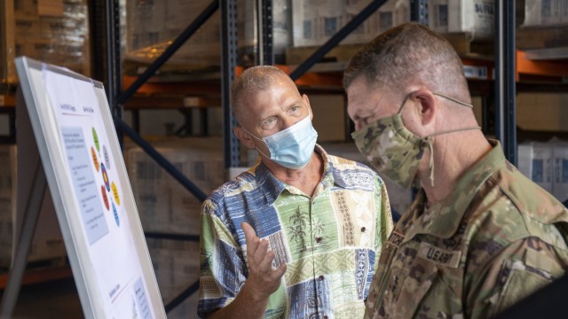 Randy Johnson from FEMA's Hawaii distribution center briefs Army Sustainment Command's commanding general Maj. Gen. Daniel Mitchell on the partnership FEMA has with the 402nd for storing disaster relief materials.