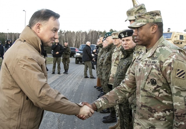 Command Sgt. Maj. Jabari Williams(Right), the senior enlisted advisor of the 2nd Armored Brigade Combat Team, 3rd Infantry Division, greets Andrzej Duda(Left), President of the Republic of Poland during a troop engagement event on Bucierz Range at Drawsko Pomorskie Training Area, Poland, in support of DEFENDER-Europe 20, March 11, 2020. (U.S. Army photo by Staff Sgt. Brian K. Ragin Jr.)