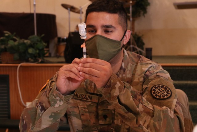 U.S. Army Spc. Mustansir Husain with the Task Force Spartan COVID Vaccination Testing Team, Michigan Army National Guard, prepares a COVID-19 vaccination in Lake Ann, Michigan, Jan. 21, 2021. The state of Michigan Department of Health and Human...