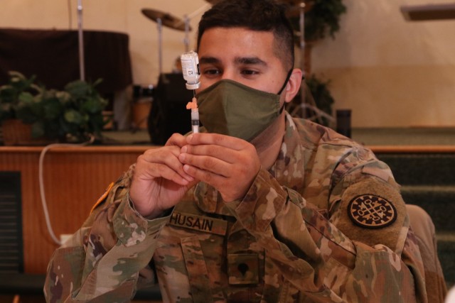 U.S. Army Spc. Mustansir Husain with the Task Force Spartan COVID Vaccination Testing Team, Michigan Army National Guard, prepares a COVID-19 vaccination in Lake Ann, Michigan, Jan. 21, 2021. The state of Michigan Department of Health and Human Services (MDHHS) requested support for the vaccinations statewide. (U.S. Army National Guard photograph by Captain Joe Legros)