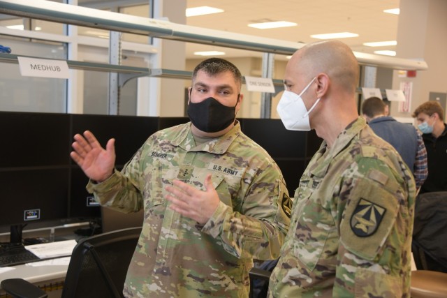 Chief Warrant Officer 4 Quinton Scherer, senior technical advisor, talks to Lt. Col. Nathan Saul, chief of integration and plans in JMC’s Joint All-Domain Command and Control division, on Jan. 13 in the C5ISR’s System Integration Lab on Aberdeen Proving Ground. (Photo by Justin Eimers / PEO C3T)
