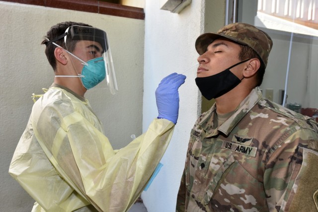 Pvt. Dylan Fahey with Alpha Company, 232nd Medical Battalion, uses a cotton swap to test Spc. Derek Mendoza assigned to Headquarters Support Company, MEDCoE, for COVID-19.