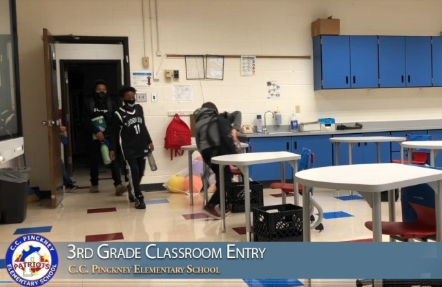 C.C. Pinckney Elementary School students demonstrate in a video the proper way to enter a classroom. (Screenshot)